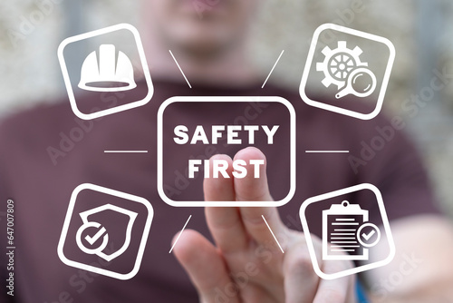 Employee using virtual touch interface presses inscription: SAFETY FIRST. Safety first, work safety, caution work hazards, danger surveillance, zero accident concept. Employees safety awareness.