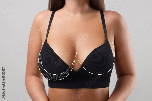 Woman with breast asymmetry on light grey background  closeup