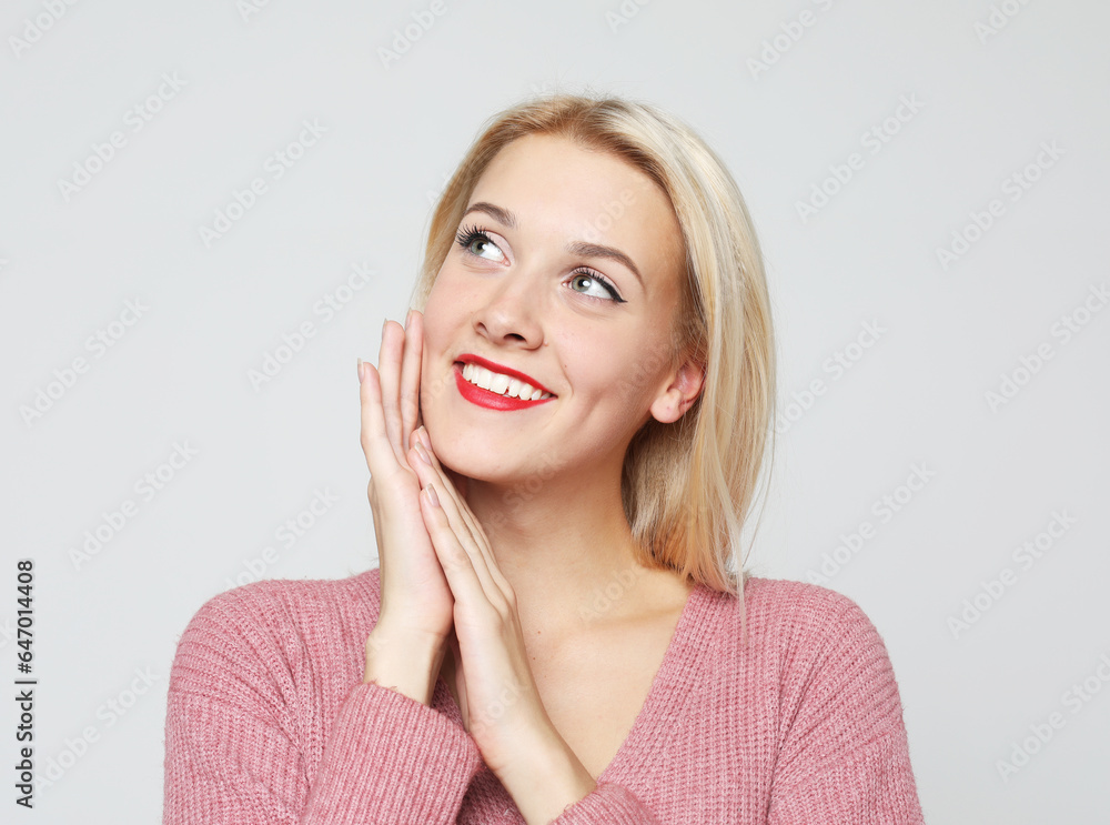 Studio shot of good-looking beautiful woman isolated against grey background. Studio shot of good-looking beautiful woman isolated against grey background.