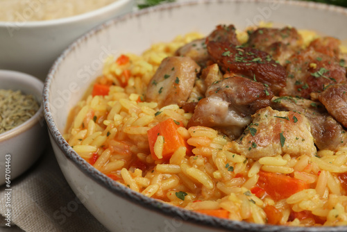 Delicious pilaf with meat in white bowl, closeup