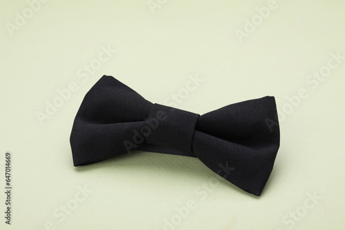 Stylish black bow tie on pale green background
