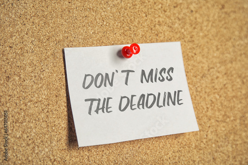 Note with reminder Don't Miss The Deadline attached to cork board