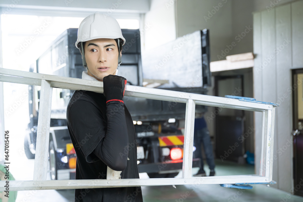 現場を確認する脚立を持った作業員 現場を確認する脚立を持った作業員