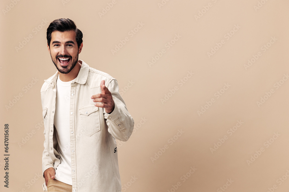Stylish man smile on a beige background in a white t-shirt and business jacket, flying clothes hero, fashionable clothing style, copy space, space for text Stylish man smile on a beige background in a white t-shirt and business jacket, flying clothes hero, fashionable clothing style, copy space, space for text