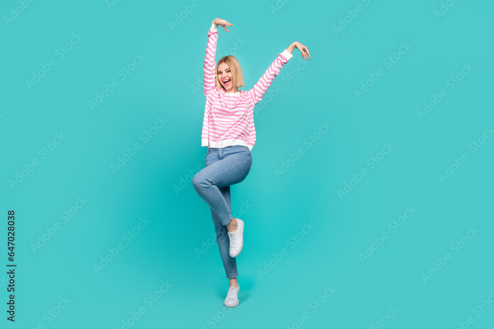 Full length photo of funky adorable girl dressed striped sweater smiling having fun isolated teal color background