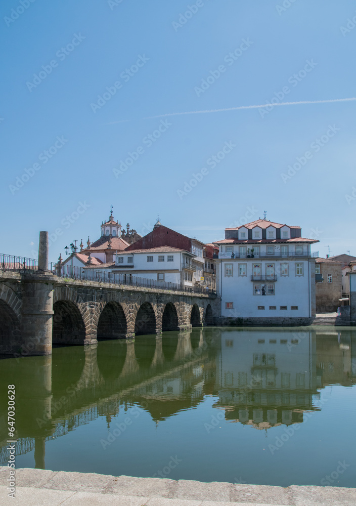 Puente romano reflejado en el rio en verano