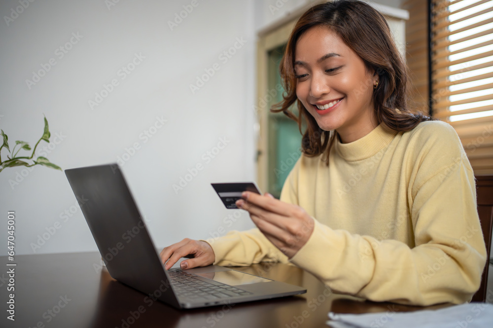 Women using Smart phone and Laptop for shopping online and payment with Credit card at home Women using Smart phone and Laptop for shopping online and payment with Credit card at home