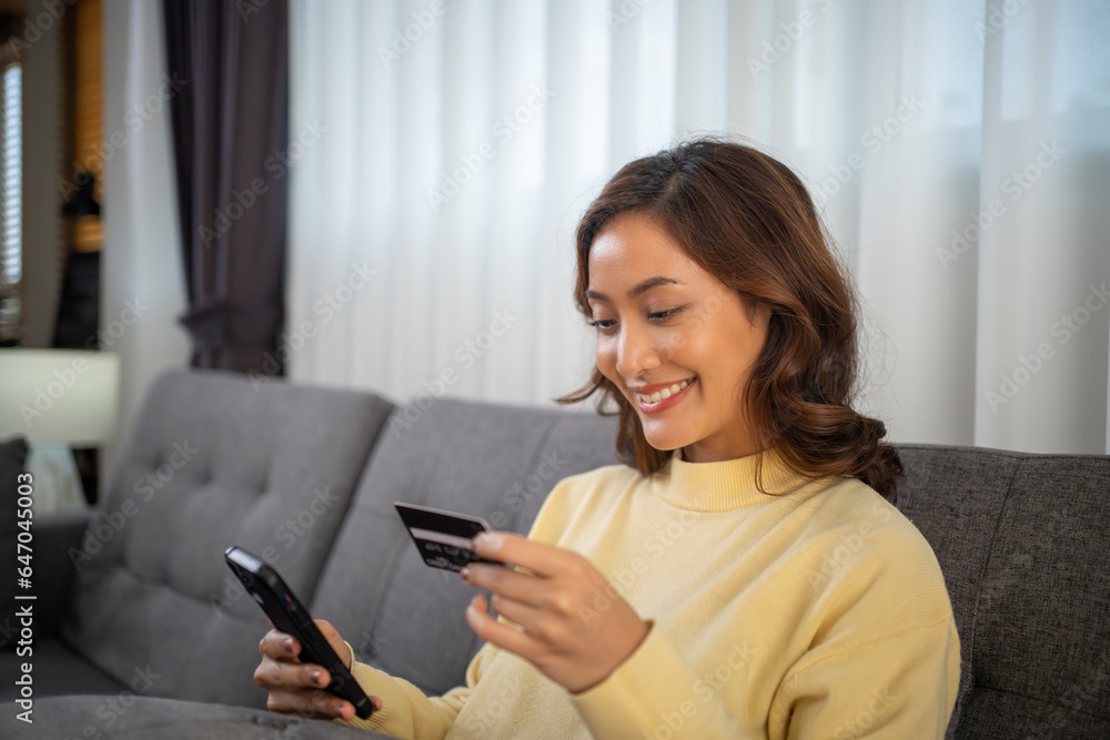 Women using Smart phone and Laptop for shopping online and payment with Credit card at home Women using Smart phone and Laptop for shopping online and payment with Credit card at home