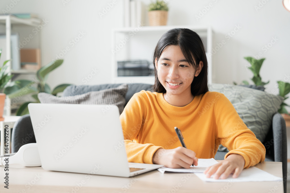 Homeschooling. Asian girl online learn doing homework, using laptop at home Homeschooling. Asian girl online learn doing homework, using laptop at home