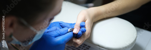 Spa specialist makes manicure for her client in beauty salon.