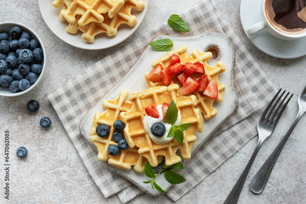 Freshly baked waffles with strawberries and blueberries