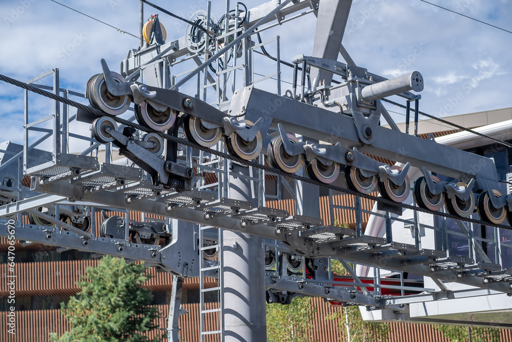 Fototapeta premium Ropeway mechanism and cable support pylon. Close-up of a cable car cabin against the sky. Cable car trip to viewpoints in the mountains. During the trip by cable car Tourists enjoy beautiful views 