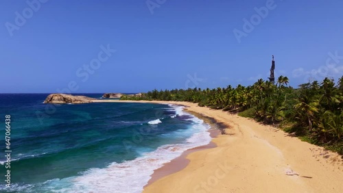 Beach on tropical island, palm trees, gold sand and blue water. statue of Christopher Columbus. photo