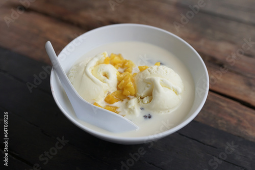Vanilla ice cream in a bowl on a wooden table