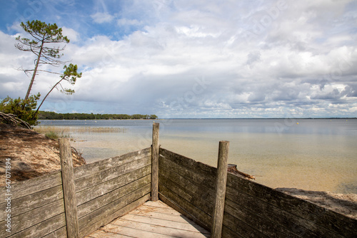 wooden palisade barrier front to sandy beach Maubuisson Carcans lake water in southwest france