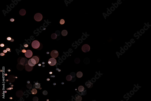 Gold rose abstract bokeh on black background for festive design with screen