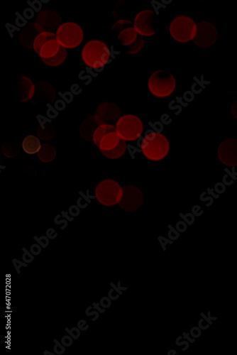 Abstract bokeh en red color on black background for festive design with screen