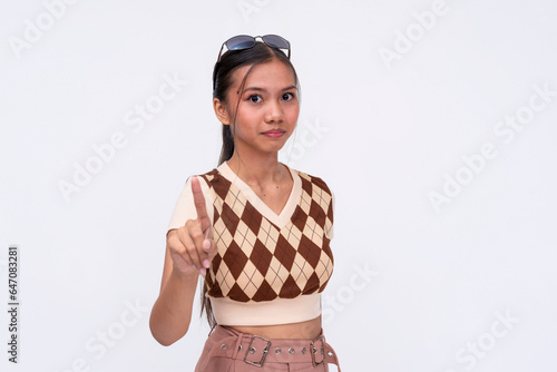 A slightly miffed asian woman giving a gentle warning and reminder. Isolated on a white background. photo