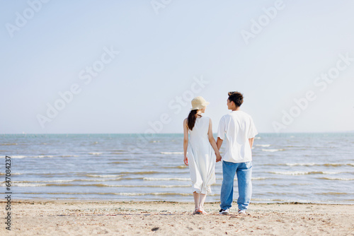 ビーチに立っている若いアジア人のカップル