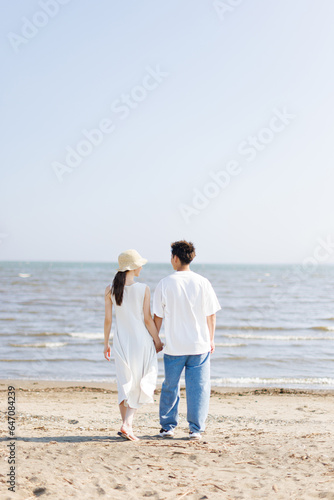ビーチに立っている若いアジア人のカップル