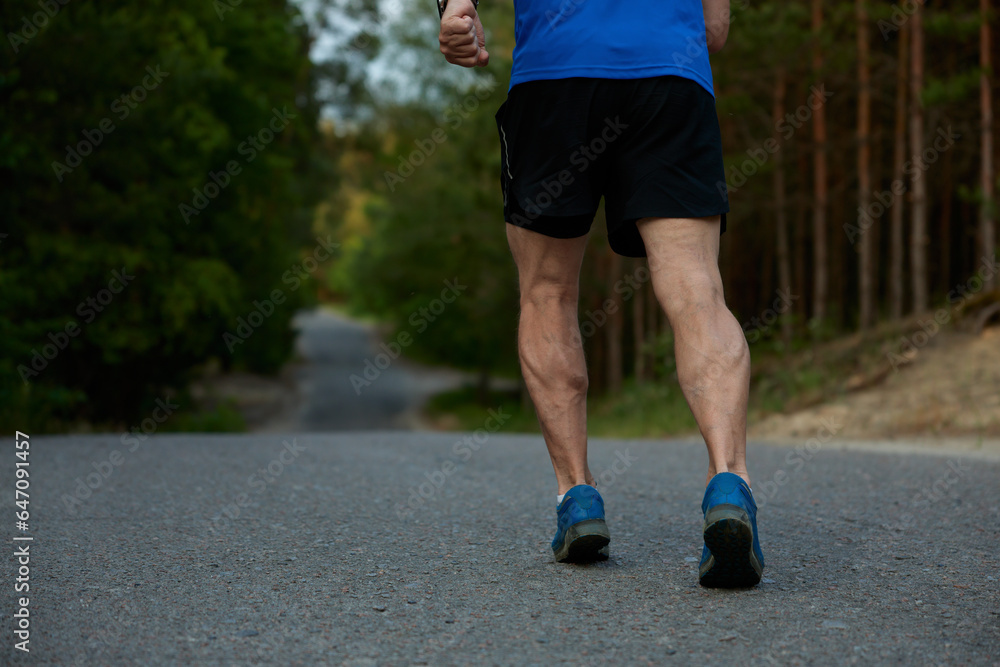 Closeup athletic strong legs of retired sportsman jogging