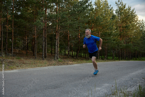 Retired senior sportsman running among road