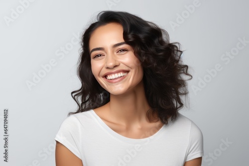 Closeup photo portrait of a beautiful young latin hispanic model woman smiling with clean teeth. Used for a dental ad. Isolated on light background.