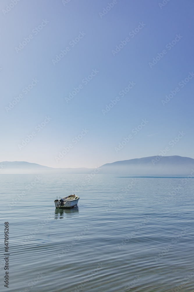 Small boat floating on the empty quiet sea.