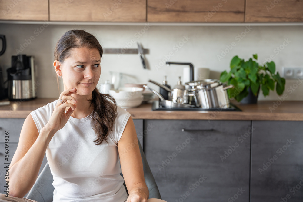 Portrait of a sad tired woman in the kitchen, domestic problems, unstable emotional state Portrait of a sad tired woman in the kitchen, domestic problems, unstable emotional state