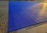blue plastic tiles with a perforated surface serve as a flat surface for organizing outdoor dance balls and events. exercise mat for mass sports such as yoga, karate and tournaments