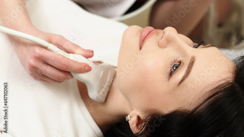 The doctor's hand conducts a medical examination of the patient using an ultrasound scanner. Close-up of an ultrasound machine and a doctor's hand working on it. Concept