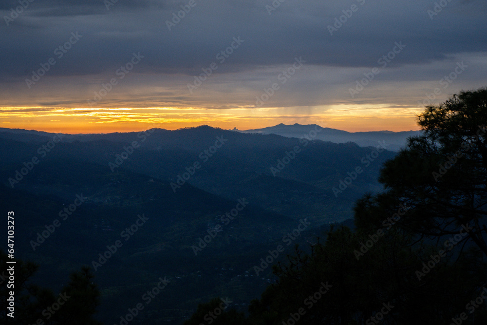 Beautiful landscape view of pine forest and sunset at himalayan range, Almora, Ranikhet, Uttarakhand, India with selective focus. Colourful sunset in Almora city, Kasardevi area.