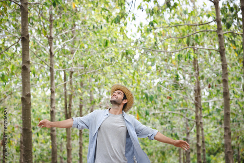 handsome man with beard in white shirt in a evergreen forest