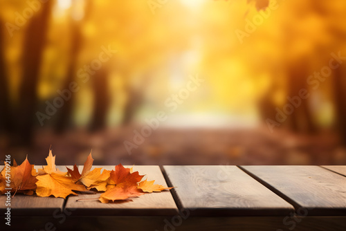 Beautiful colourful natural autumn background for presentation. Fallen dry orange leaves on wooden boards against the backdrop of a blurry autumn park