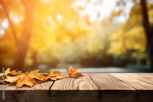 Beautiful colourful natural autumn background for presentation. Fallen dry orange leaves on wooden boards against the backdrop of a blurry autumn park