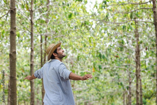 handsome man with beard in white shirt in a evergreen forest