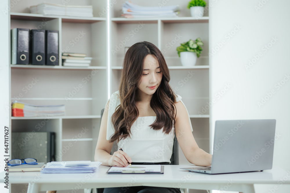 Young independent Asian woman working on laptop computer in modern office Perform accounting analysis, report real estate investment data. Financial concepts and tax system Young independent Asian woman working on laptop computer in modern office Perform accounting analysis, report real estate investment data. Financial concepts and tax system