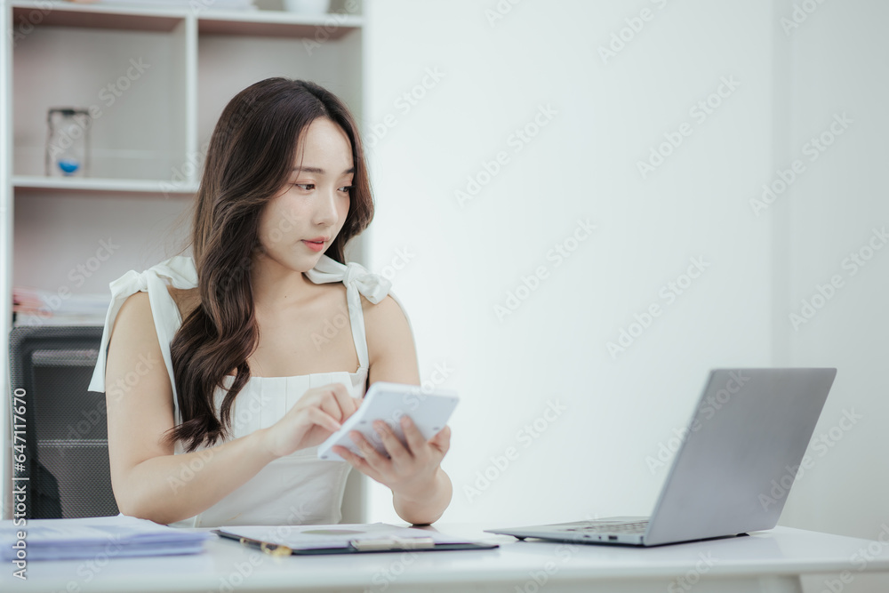 Young independent Asian woman working on laptop computer in modern office Perform accounting analysis, report real estate investment data. Financial concepts and tax system Young independent Asian woman working on laptop computer in modern office Perform accounting analysis, report real estate investment data. Financial concepts and tax system