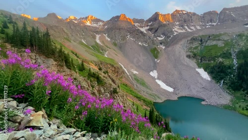 Cinematic aerial drone alpine sunset at Blue Lakes Colorado Mount Sniffels Dallas Peaks Wilderness snow 14er peak purple wildflowers Ridgway Telluride Ouray Silverton hike slow pan to the right photo