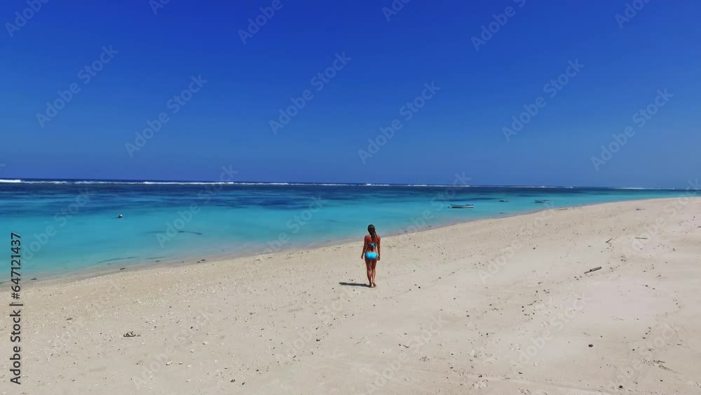 Beautiful authentic woman run in surf waves on empty sandy beach at Bali island Beautiful authentic woman run in surf waves on empty sandy beach at Bali island