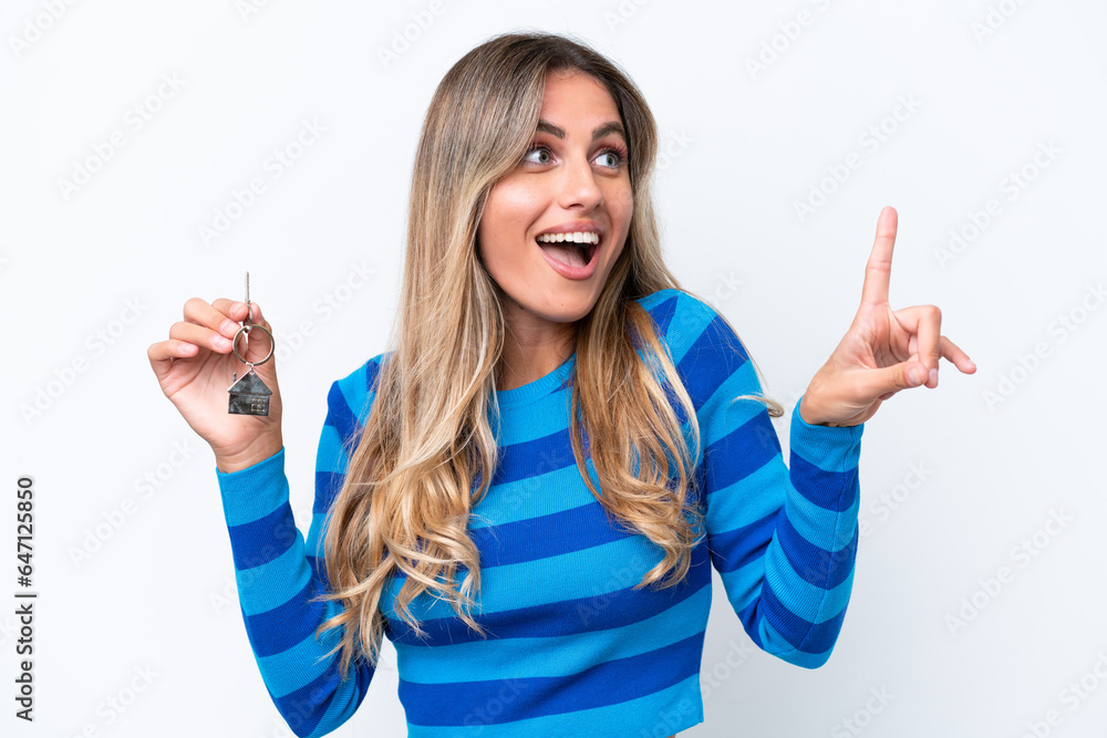 Young pretty Uruguayan woman holding home keys isolated on white background intending to realizes the solution while lifting a finger up Young pretty Uruguayan woman holding home keys isolated on white background intending to realizes the solution while lifting a finger up