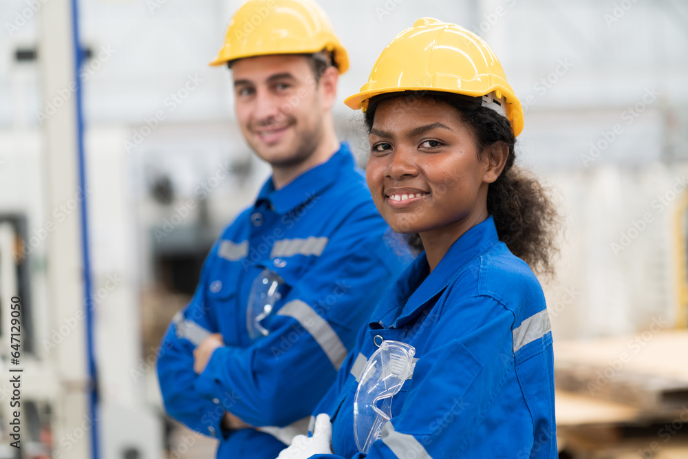 Male and female engineer worker wearing safety uniform and helmet standing with crossed arms in industry factory. Group of engineer at workplace. Team of engineer in line production Male and female engineer worker wearing safety uniform and helmet standing with crossed arms in industry factory. Group of engineer at workplace. Team of engineer in line production