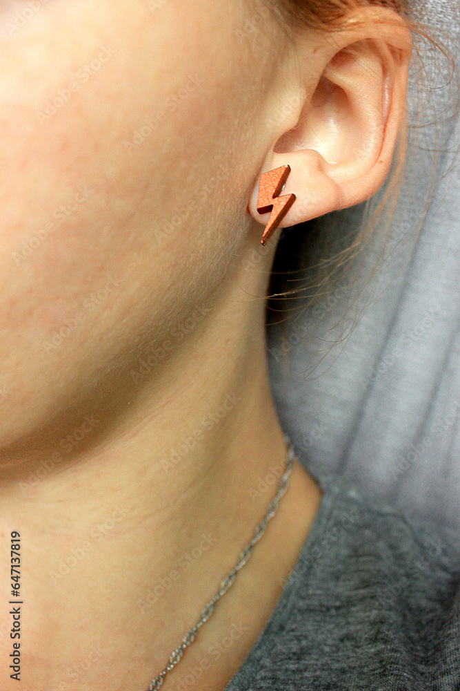 Young Woman with bronse earring lightning shape. Tolerance, diversity and gender identity concept. Young Woman with bronse earring lightning shape. Tolerance, diversity and gender identity concept.