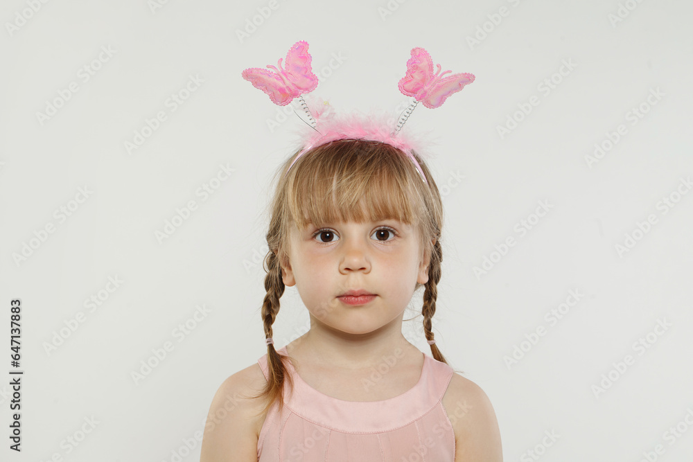Cute child in pink hairband, portrait. Little girl in hairdeco on white background Cute child in pink hairband, portrait. Little girl in hairdeco on white background