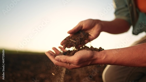 soil in the hands of the farmer. agriculture. close-up of a farmers hands holding sun black soil in their hands, fertile land. garden field ground fertile concept. worker holding soil plowed field