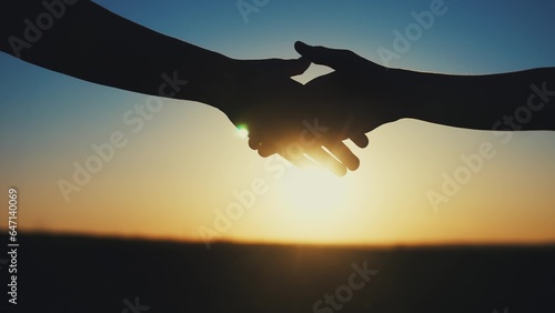 handshake farmers silhouette. agriculture business concept. close-up farmers hands silhouette shaking hands sun silhouette making a contract agreement. farmers negotiations in agriculture business