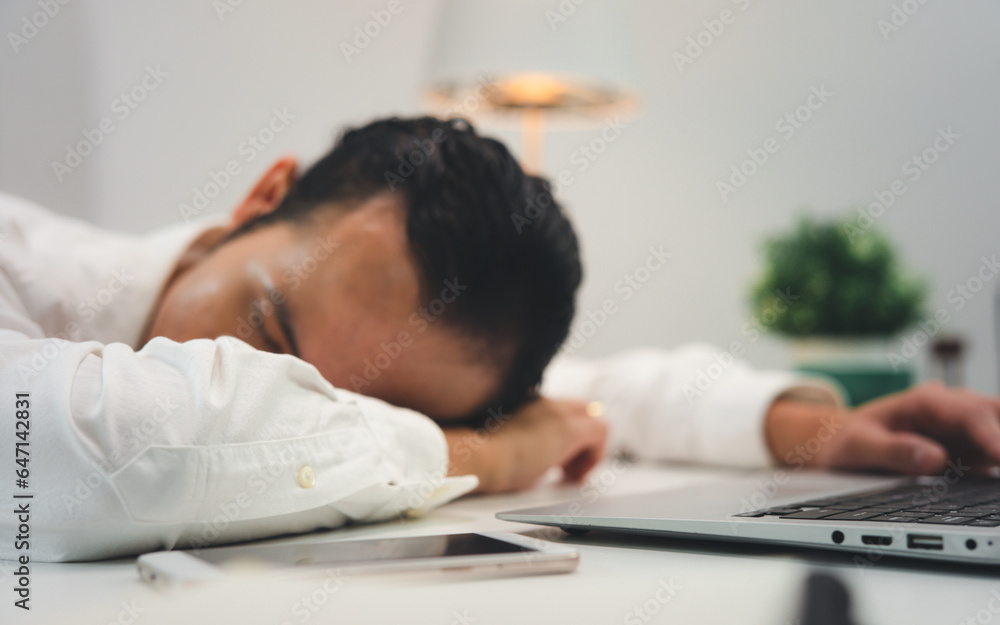 Asian businessman sleeping tired lying on the table, man at work
Asian businessman sleeping tired lying on the table, man at work
