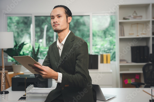 Businessman using digital tablet at desk in office 