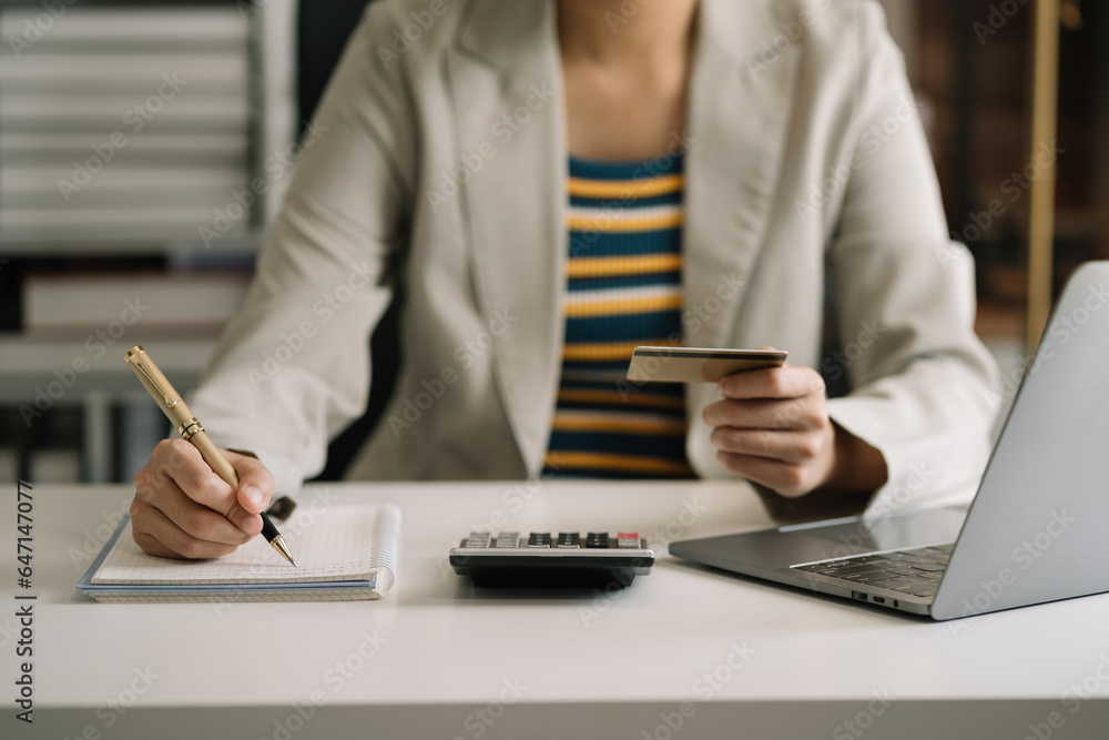 Business woman calculating monthly office expenses, taxes, bank account