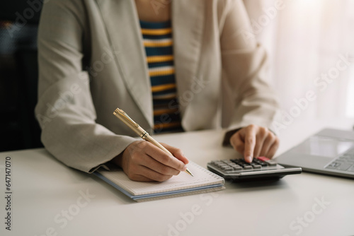 Hand woman doing finances and calculate on desk about cost at home office.